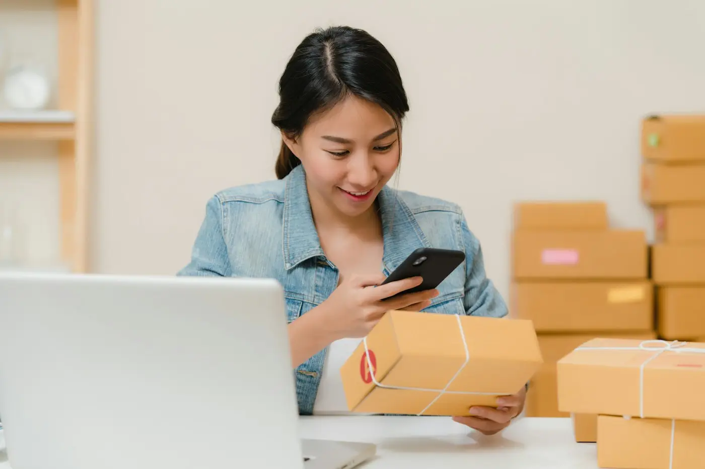 Small business owner packing online orders (illustrative stock photo)