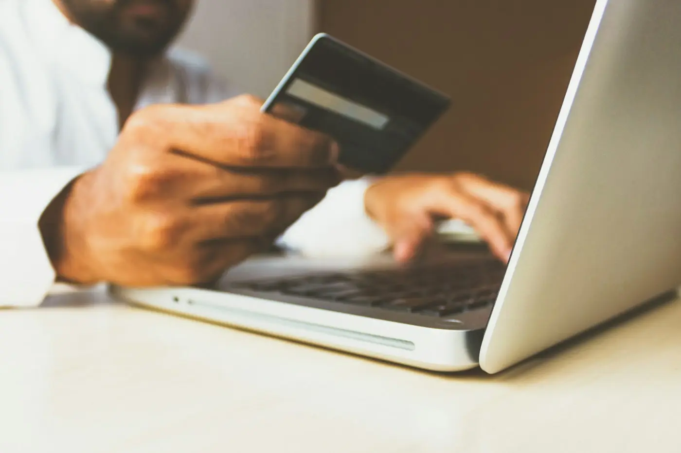 Person paying online with a credit card and laptop (illustrative stock photo)